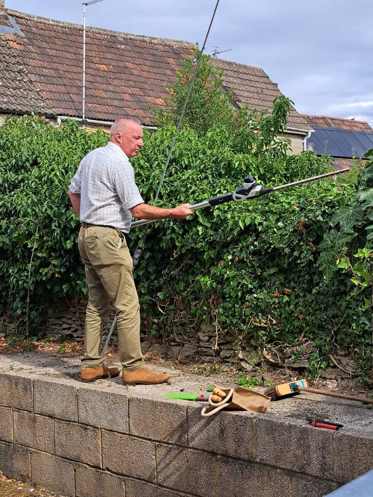 Photograph of a volunteer cutting the grass edge