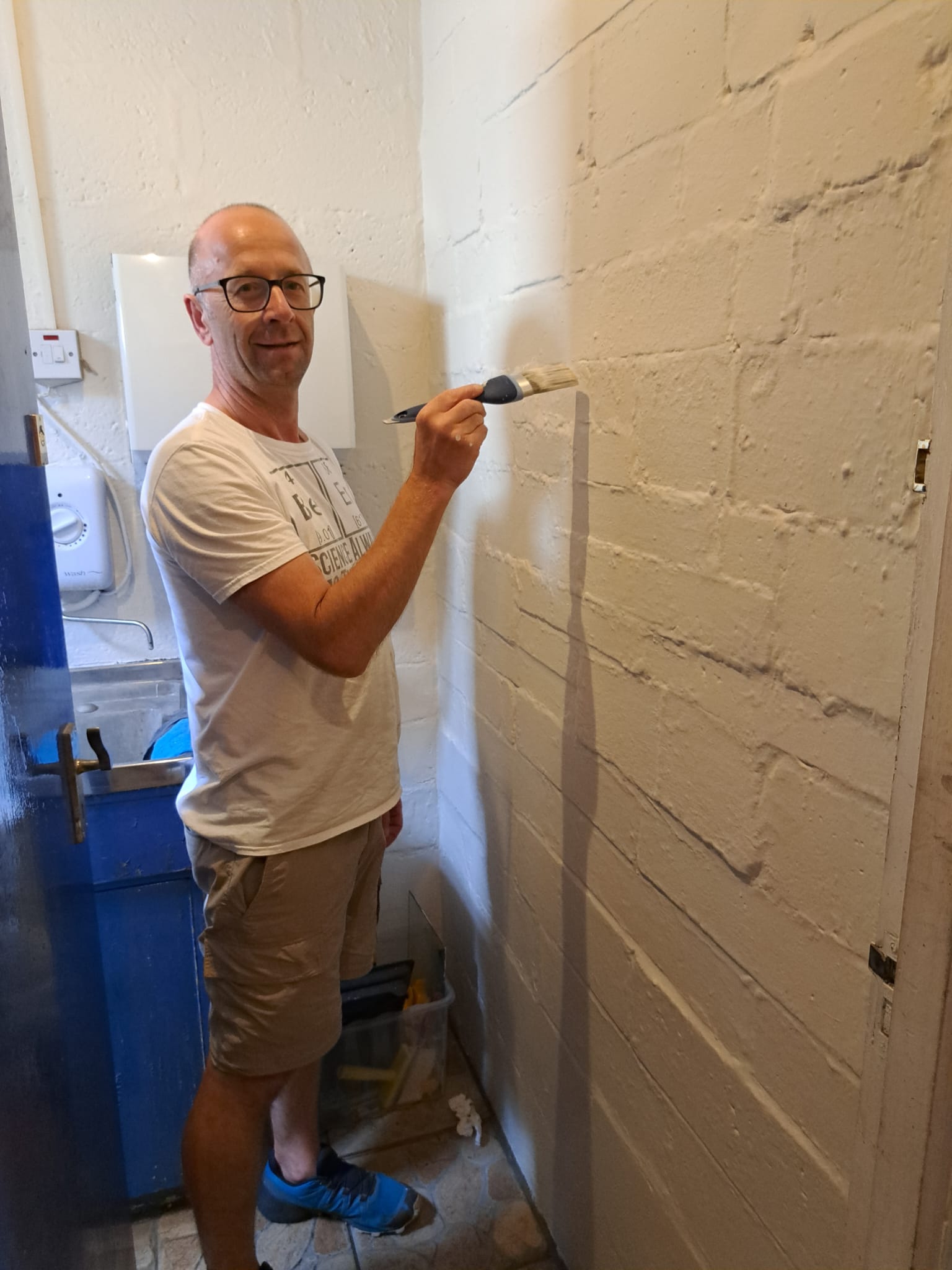 Photograph of a volunteer painting a wall